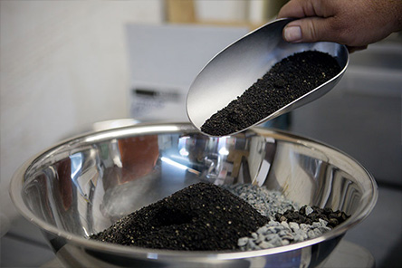 Pouring asphalt mix components into a bowl