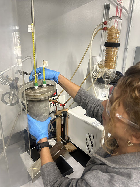 Emulsion lab technician securing distillation apparatus