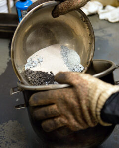 asphalt mix designer dumping multiple sized aggregates into bowl